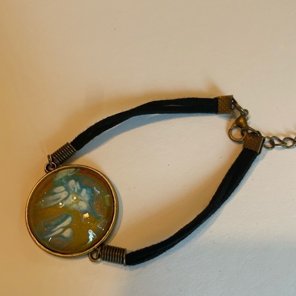 Hand painted acrylic design on glass bracelet. Attached to metal. Adjustable